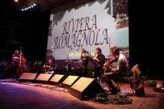 REGGIO EMILIA. PIAZZA PRAMPOLINI. "GRANDE SFIDA ALL'ULTIMO VALZER", GARA TRA ORCHESTRE DI LISCIO. "I VIOLINI DI SANTA VITTORIA" CONTRO LA FORMAZIONE "SECONDO A NESSUNO". MUSICA FOLK ROMAGNOLA. NELLO SCHERMO PASSATO FILMATI E FOTO DEDICATI A SECONDO CASADEI.